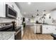 Bright, open kitchen with stainless steel appliances, granite countertops, and wood-look flooring at 5030 S 23Rd Ave, Phoenix, AZ 85041