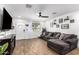 Comfortable living room featuring hardwood floors, a ceiling fan, and a large sectional sofa at 5030 S 23Rd Ave, Phoenix, AZ 85041