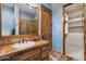 Bathroom featuring a sink, wooden cabinets, mirror, and a view into the tiled shower and walk-in closet at 5203 N 179Th Dr, Litchfield Park, AZ 85340