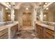 Elegant bathroom featuring dual sinks, granite countertops, and a large wooden door at 5203 N 179Th Dr, Litchfield Park, AZ 85340