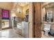 Bathroom featuring a soaking tub, granite floors and vanity, and decorative mirrors at 5203 N 179Th Dr, Litchfield Park, AZ 85340