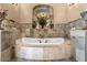 Elegant soaking tub in a decorative alcove with tile surround and tile floors at 5203 N 179Th Dr, Litchfield Park, AZ 85340