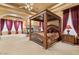 Grand bedroom with a four-poster bed, elegant drapes, and a cozy fireplace at 5203 N 179Th Dr, Litchfield Park, AZ 85340