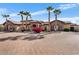 Daytime view of a home featuring desert landscaping and mature palm trees lining the property and brick driveway at 5203 N 179Th Dr, Litchfield Park, AZ 85340