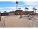Daytime view of desert landscaping, mature palm trees, and a brick driveway leading to the luxurious home at 5203 N 179Th Dr, Litchfield Park, AZ 85340