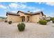 Elegant home exterior with neutral tones, desert landscaping, and a well-manicured lawn at 5203 N 179Th Dr, Litchfield Park, AZ 85340
