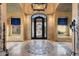 Foyer featuring ornate iron front door, high ceilings, arched windows, custom tile flooring and stone accents at 5203 N 179Th Dr, Litchfield Park, AZ 85340