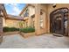 Close daytime view of the ornate iron front door, stucco exterior and manicured landscaping at 5203 N 179Th Dr, Litchfield Park, AZ 85340