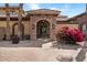 Daytime view of desert landscaping, bushes and flowers in front of home's entry and arched entryway at 5203 N 179Th Dr, Litchfield Park, AZ 85340