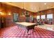Spacious game room featuring a billiard table, dark wood paneling, and comfortable seating area at 5203 N 179Th Dr, Litchfield Park, AZ 85340