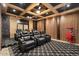 Comfortable home theater with tiered seating, coffered ceiling, and large screen for immersive entertainment at 5203 N 179Th Dr, Litchfield Park, AZ 85340