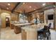 Open-concept kitchen with granite counters, custom cabinets, and bar seating at 5203 N 179Th Dr, Litchfield Park, AZ 85340