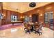 Spacious living room with hardwood floors, pool table, formal table and decorative paneling at 5203 N 179Th Dr, Litchfield Park, AZ 85340