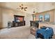 Open concept main bedroom with dining area, tv, sitting chair and ceiling fan at 5203 N 179Th Dr, Litchfield Park, AZ 85340