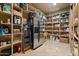 Organized pantry featuring ample shelving, stainless steel refrigerator, and plenty of space for storage at 5203 N 179Th Dr, Litchfield Park, AZ 85340