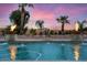 Inviting pool with fire bowls, fountains, and lush landscaping creates a resort-like atmosphere at sunset at 5203 N 179Th Dr, Litchfield Park, AZ 85340