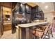 Custom wet bar features granite countertops, dark wood cabinetry, and bar seating, ideal for entertaining guests at 5203 N 179Th Dr, Litchfield Park, AZ 85340