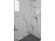 Close up of a shower featuring marble tile walls and contrasting black and white mosaic tile floor at 533 N Sirrine --, Mesa, AZ 85201
