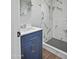 Bathroom featuring a blue vanity with a sink and a shower featuring marble tile walls and mosaic tile floor at 533 N Sirrine --, Mesa, AZ 85201
