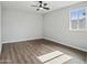 Empty bedroom featuring wood look flooring, a ceiling fan, a window, and neutral-colored walls at 533 N Sirrine --, Mesa, AZ 85201