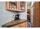 Kitchen cabinet area featuring glass front cabinets and coffee machine, adding charm and functionality at 712 Felspar Dr, Apache Junction, AZ 85119