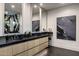 A bathroom with modern vanities, black countertops and dark tile flooring at 7120 E Paradise Ranch Rd, Paradise Valley, AZ 85253