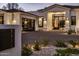 Close-up view of a home with a glass garage door, desert landscaping, and a brick driveway at 7120 E Paradise Ranch Rd, Paradise Valley, AZ 85253
