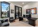 Modern office with a dark desk, glass doors, and views of the front yard at 7120 E Paradise Ranch Rd, Paradise Valley, AZ 85253