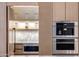 Modern kitchen cabinetry showcasing integrated appliances and open shelving for storage at 7120 E Paradise Ranch Rd, Paradise Valley, AZ 85253
