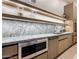Kitchen features marble backsplash and counter, stainless steel appliances and custom wood cabinets at 7120 E Paradise Ranch Rd, Paradise Valley, AZ 85253