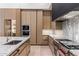 A modern kitchen with marble countertops, stainless steel appliances, and custom wood cabinetry at 7120 E Paradise Ranch Rd, Paradise Valley, AZ 85253