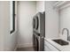Well-lit laundry room with stacked washer and dryer and white cabinets at 7120 E Paradise Ranch Rd, Paradise Valley, AZ 85253