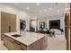 Luxurious living area with a sleek kitchen island, dining table, and stylish fireplace at 7120 E Paradise Ranch Rd, Paradise Valley, AZ 85253