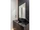 Modern powder room with a black marble countertop and accent lighting at 7120 E Paradise Ranch Rd, Paradise Valley, AZ 85253