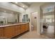 Well-lit bathroom with double sinks, granite countertops, tile floors, and a view to the bedroom at 7445 E Eagle Crest Dr # 1094, Mesa, AZ 85207
