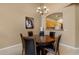 Dining room with round wood table, seating for four, and an arched window view of the kitchen at 7445 E Eagle Crest Dr # 1094, Mesa, AZ 85207