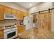 Kitchen featuring wooden cabinets, granite counters, and access to the laundry area at 7445 E Eagle Crest Dr # 1094, Mesa, AZ 85207