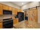 Kitchen with updated appliances, wooden cabinets, and a sliding barn door at 7445 E Eagle Crest Dr # 1094, Mesa, AZ 85207