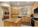 Bright kitchen features a center island with granite countertops, light wood cabinets, and modern appliances at 7445 E Eagle Crest Dr # 1094, Mesa, AZ 85207