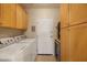 Laundry room with wooden cabinets, white washer and dryer, and tiled floor at 7445 E Eagle Crest Dr # 1094, Mesa, AZ 85207