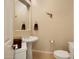 Stylish powder room featuring a pedestal sink, decorative mirror, and toilet at 7445 E Eagle Crest Dr # 1094, Mesa, AZ 85207
