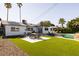 Backyard featuring dining table, lounge chairs, pool, and lush green grass at 7506 E Granada Rd, Scottsdale, AZ 85257