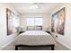 Bright bedroom featuring abstract artwork and a queen bed with decorative pillows and duvet at 7506 E Granada Rd, Scottsdale, AZ 85257