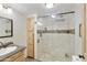 Bright bathroom featuring tiled shower with glass door and natural wood cabinets at 8312 E Pueblo Ave, Mesa, AZ 85208