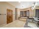 Luxurious bathroom featuring a soaking tub with shuttered windows and double granite vanity sinks at 9515 E Julep Cir, Mesa, AZ 85207