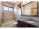 Bathroom featuring a granite countertop vanity, framed mirror, and a tub/shower combo with a window at 9515 E Julep Cir, Mesa, AZ 85207
