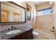 Bathroom featuring a granite countertop vanity, decorative mirror, and a bathtub with tile surround at 9515 E Julep Cir, Mesa, AZ 85207