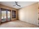 Bedroom featuring a ceiling fan and shuttered doors to a balcony, with a neutral color palette at 9515 E Julep Cir, Mesa, AZ 85207