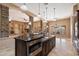 Stylish kitchen featuring a dark wood island, stone accents, and modern appliances at 9515 E Julep Cir, Mesa, AZ 85207