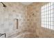Elegant shower with decorative tile surround, a built-in niche, and a glass block window for natural light at 9515 E Julep Cir, Mesa, AZ 85207